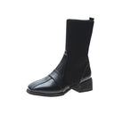 Black leather ankle boot with ribbed knit upper, low block heel, and sleek design. Women's fashion footwear, stylish and versatile boot.