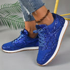 Blue glitter sneakers with white soles, worn with frayed jeans and a braided anklet. Stylish women's footwear, casual fashion, trendy shoes.