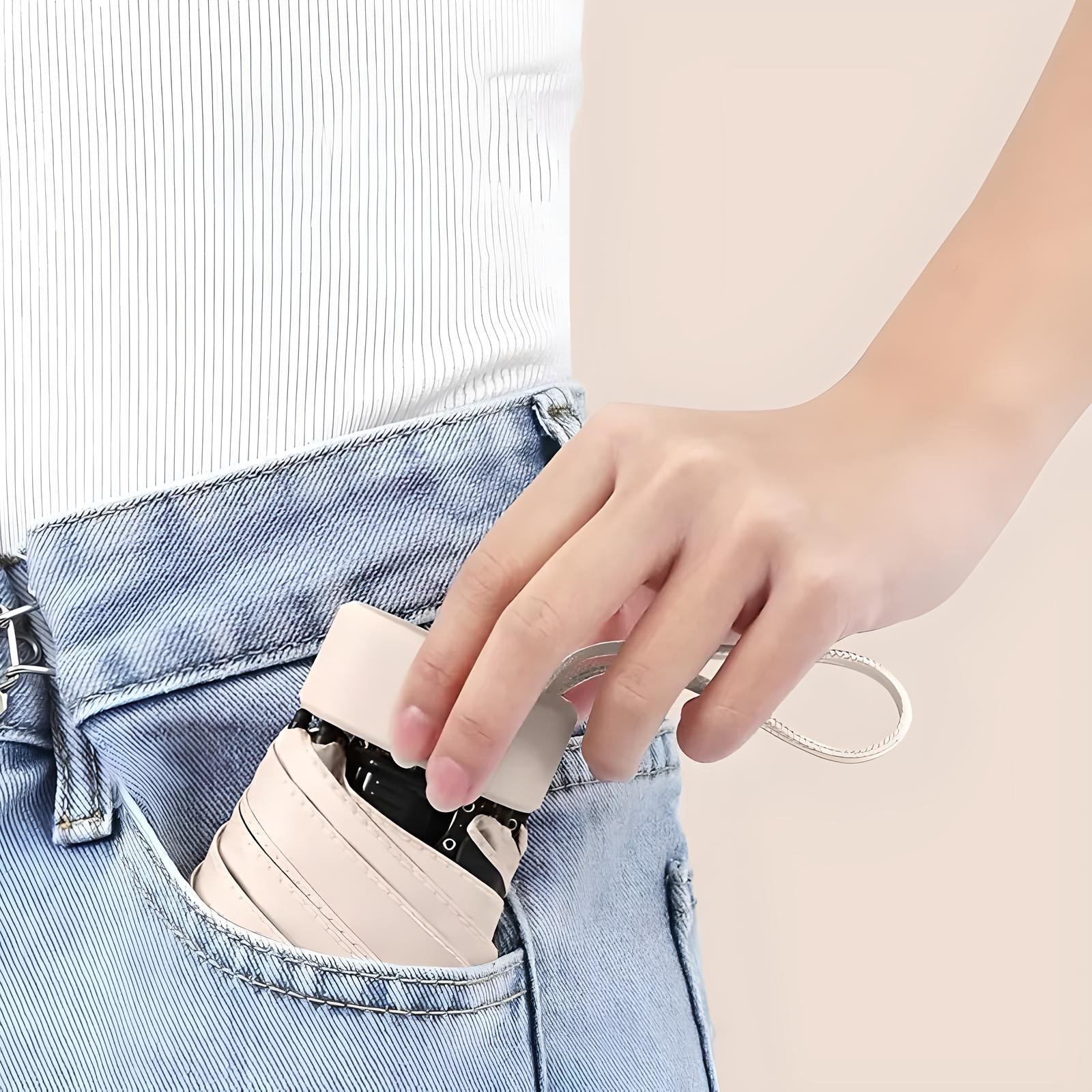 Hand placing compact beige leather wallet with strap into blue jeans pocket, showcasing minimalist design and convenient portability.