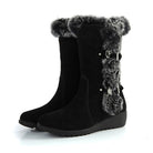 Black suede winter boots with faux fur trim and buckle accents, featuring a wedge heel. Ideal for cold weather fashion and comfort.