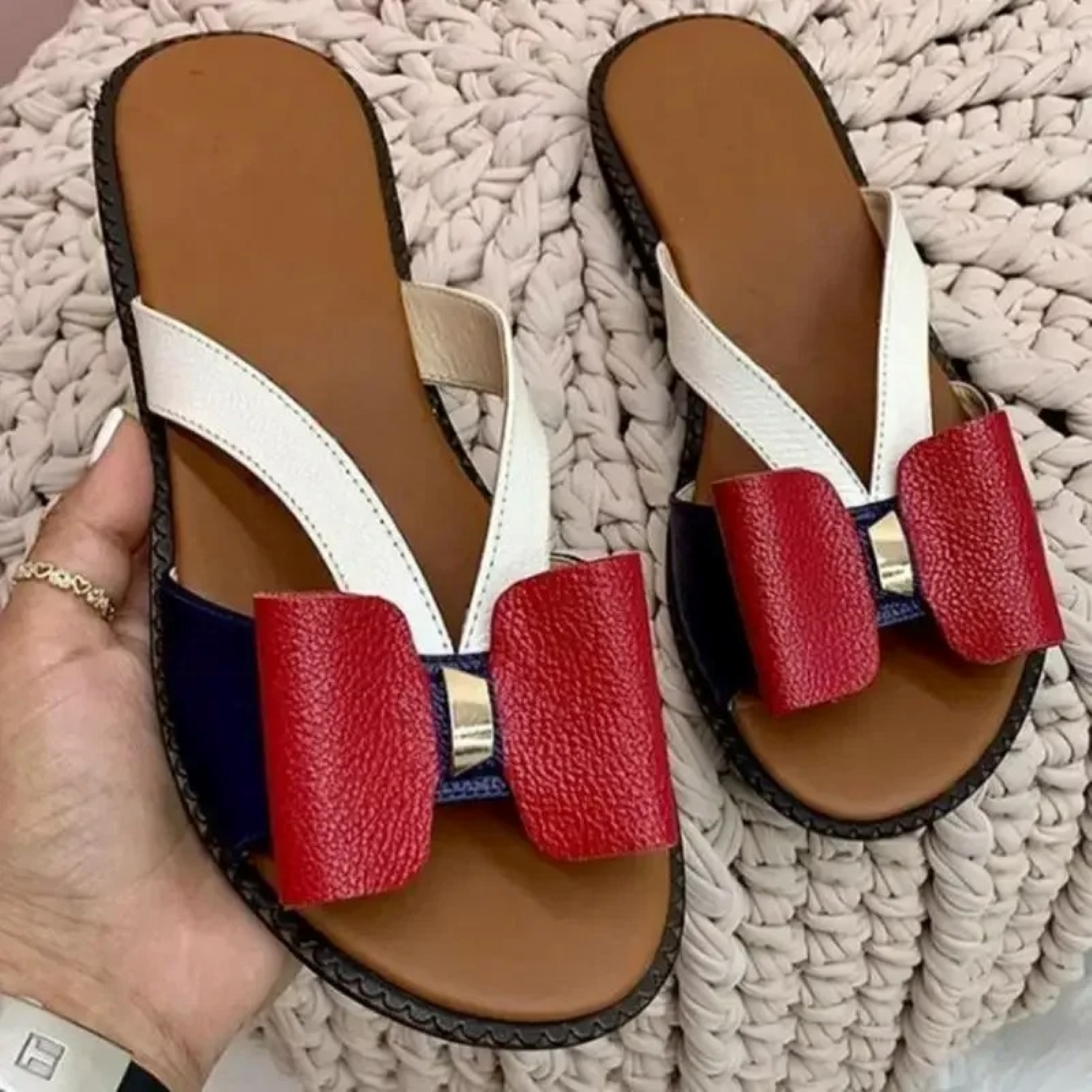 Women's stylish sandals with red bow, white straps, and brown sole. Perfect for summer fashion. Comfortable and trendy footwear for casual wear.