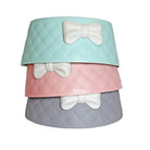 Stacked quilted pet bowls in pastel colors with bow accents; stylish dog or cat feeding accessories; modern pet dish design.