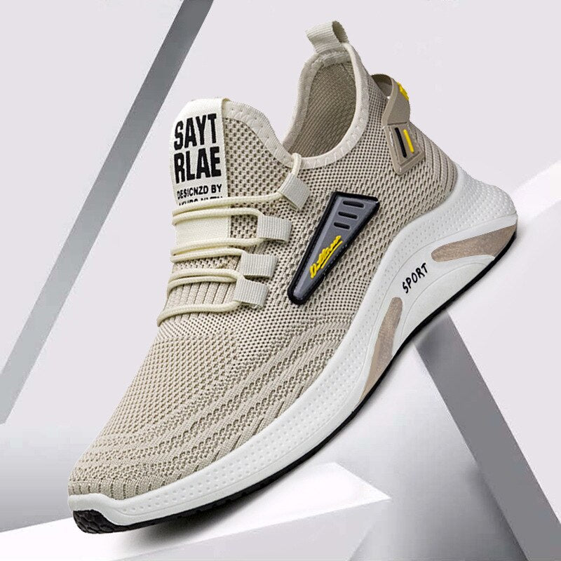 Beige athletic sneaker with mesh upper, branded tongue, and cushioned sole on geometric background. Stylish running shoe for men.