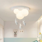 Modern ceiling light fixture with three white spherical lamps and hanging polar bear decorations, ideal for children's room decor and playful lighting.