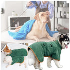 Dog grooming session with Labrador under blue towel, and two dogs wearing green microfiber drying robes. Pet care, dog grooming, drying coats.