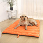 Orange waterproof foldable dog mat for outdoor travel, durable pet bedding on wooden floor.