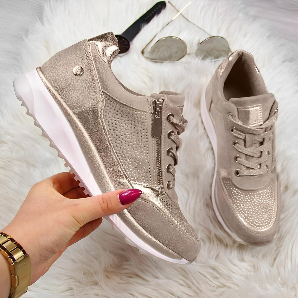 Stylish beige women's sneakers with metallic accents, lace-up and zipper closure, displayed on a fluffy white background. Fashionable casual footwear.