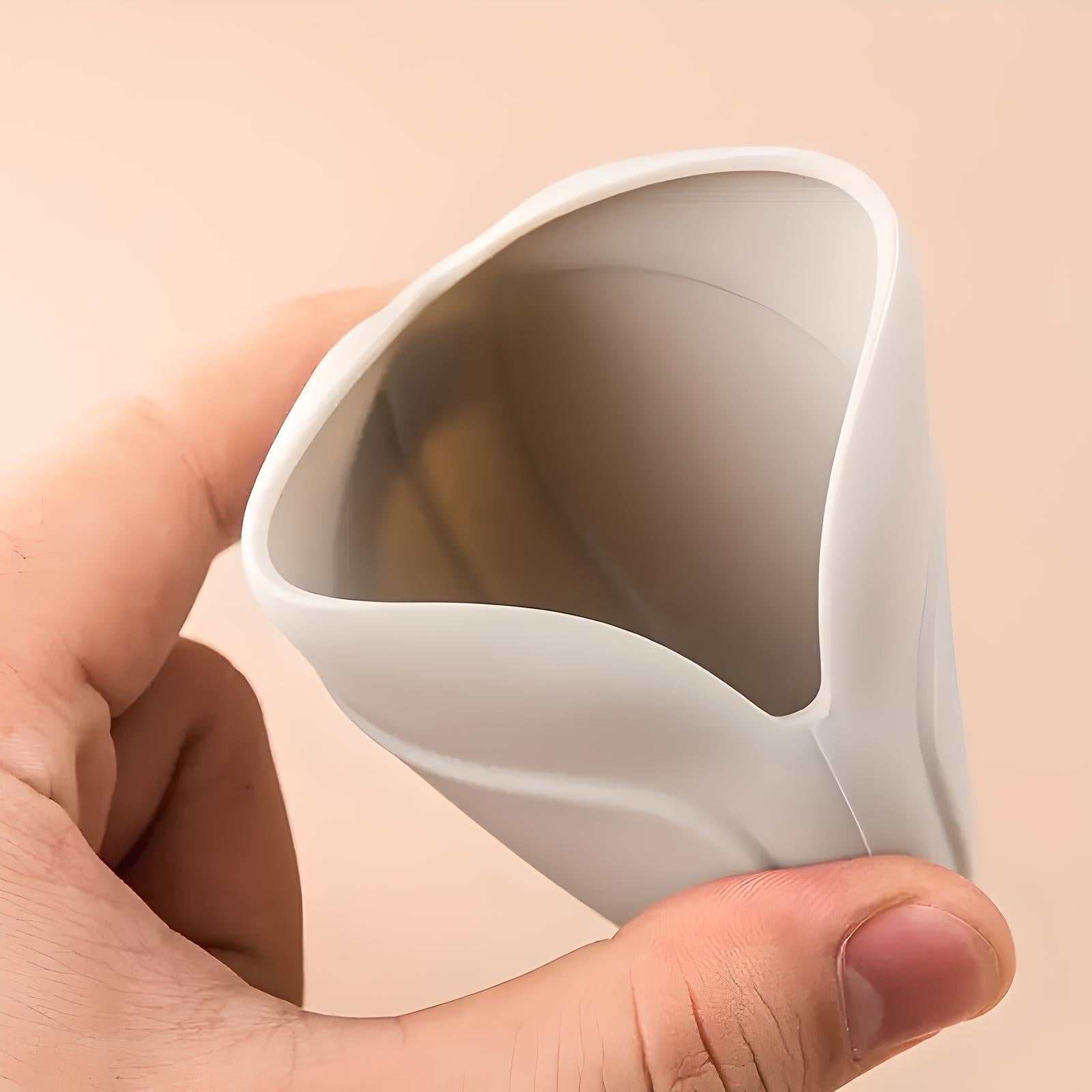 Hand holding a white silicone menstrual cup, showcasing its flexible, ergonomic design. Eco-friendly, reusable feminine hygiene product.