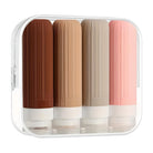 Set of four silicone travel bottles in brown, beige, and pink, stored in a transparent case. Ideal for toiletries, leak-proof, TSA-approved containers.