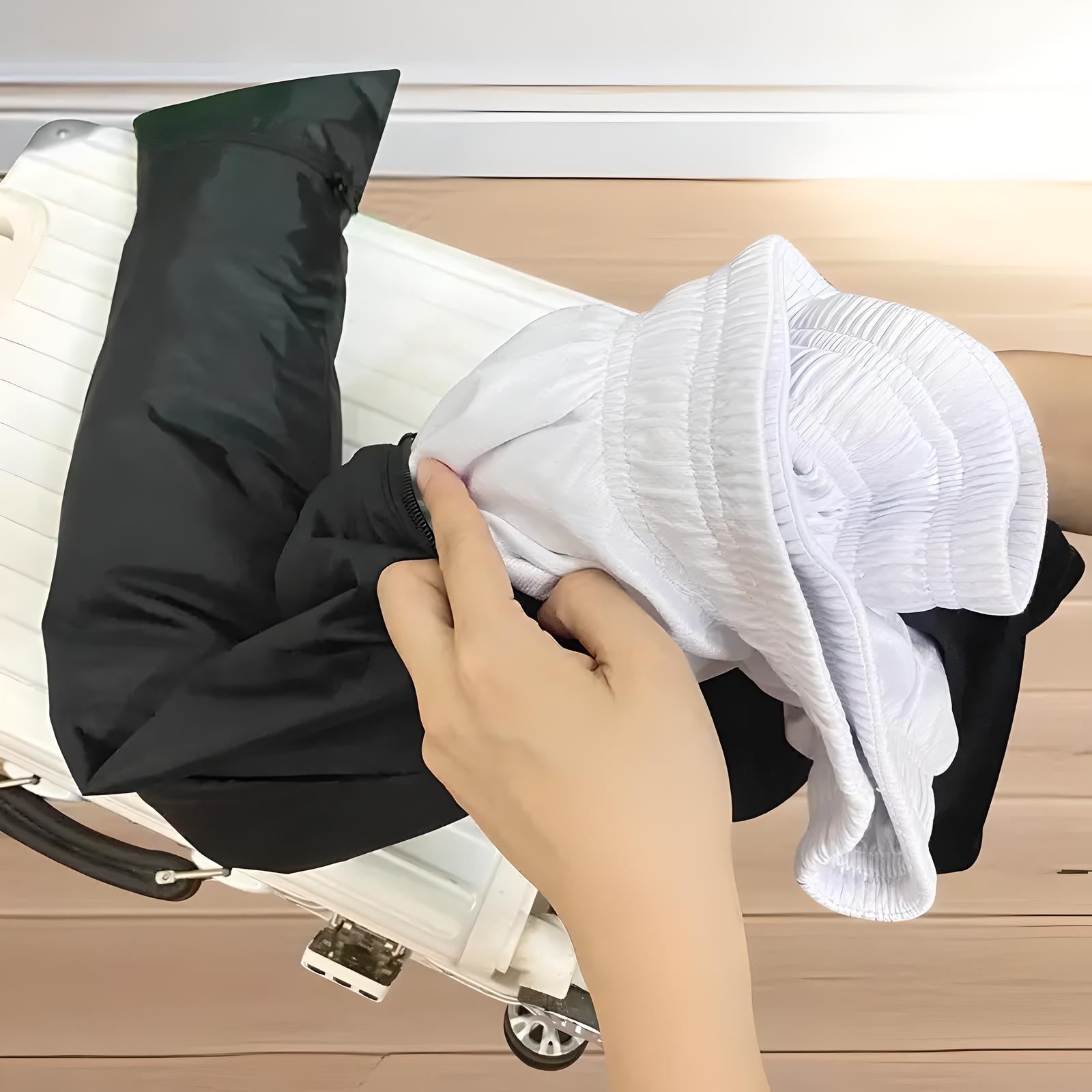 Person packing a white suitcase with black and white clothing, preparing for travel. Efficient packing, travel essentials, organized luggage.