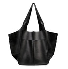 Sleek black leather tote bag with wide straps and spacious design, perfect for fashion-forward individuals seeking a stylish, versatile accessory.