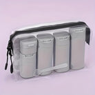 Clear travel toiletry bag with four gray refillable bottles and a small spatula, ideal for organizing liquids, TSA-approved, leak-proof design.