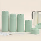 Set of mint green travel-sized refillable bottles and containers for toiletries, featuring a sleek design, perfect for eco-friendly travel essentials.