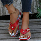 Red women's flip-flops with non-slip thick soles, featuring decorative buckles, worn with jeans and a gold anklet. Summer sandals fashion.