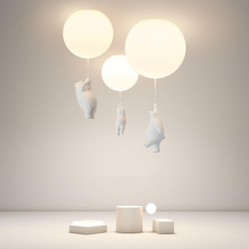 Modern ceiling light fixture with three glowing spherical lamps and playful bear sculptures, ideal for contemporary home decor and ambient lighting.