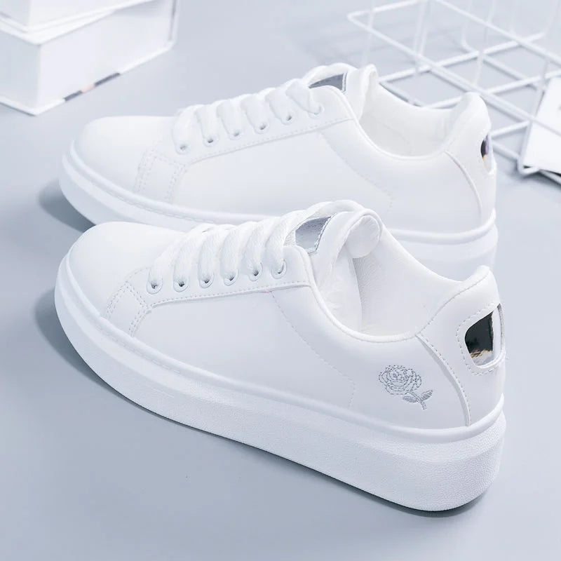 White women's casual sneakers with embroidered floral design, lace-up closure, breathable material. Perfect for spring and fall fashion trends.