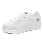 White women's casual sneakers with embroidered floral design, lace-up closure, breathable material. Perfect for spring and fall fashion.