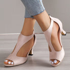 Elegant women's pink high-heeled sandals with open toe and cutout design, paired with light blue jeans. Perfect for summer fashion trends.