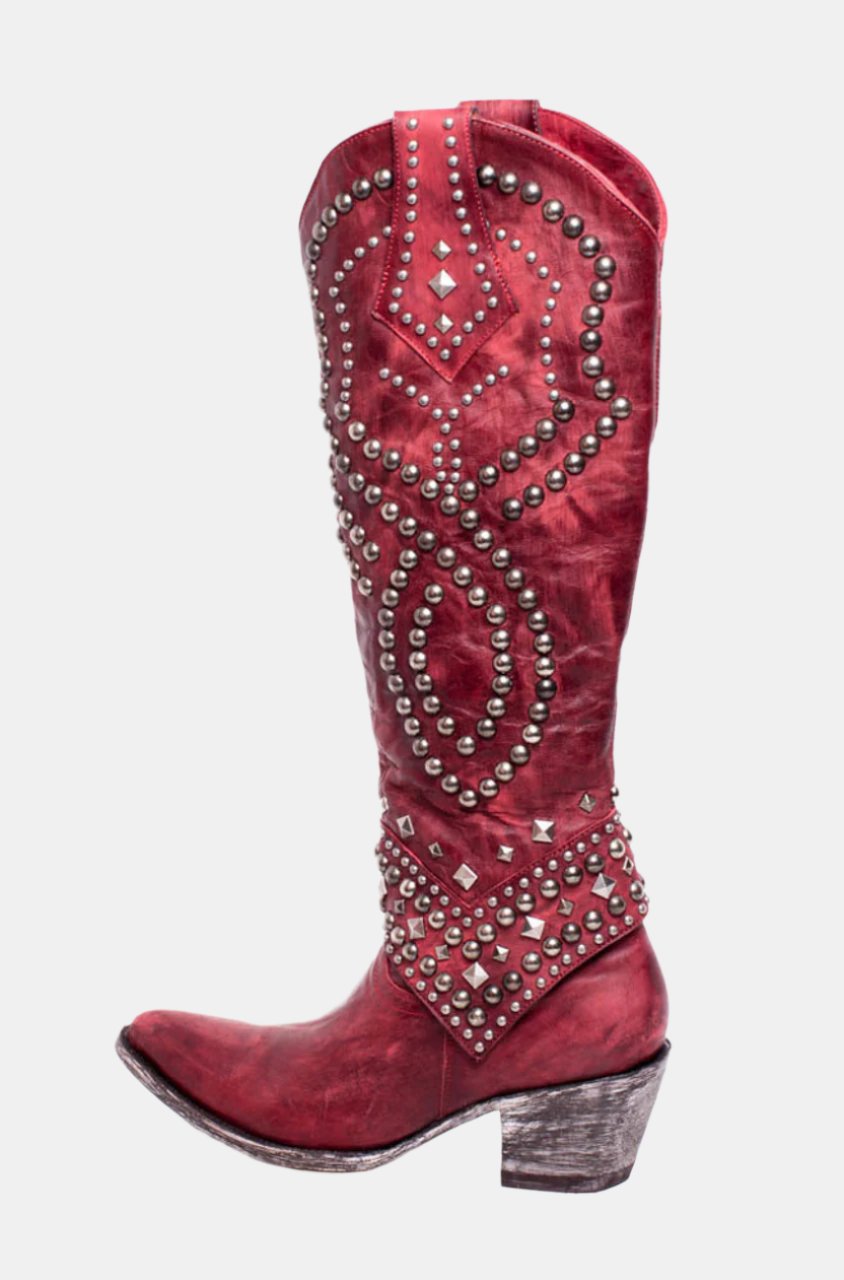 Red leather cowboy boot with silver stud embellishments, featuring a pointed toe and stacked heel. Western fashion footwear, stylish and durable.