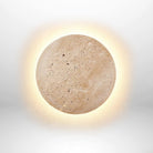 Modern round travertine wall sconce with warm LED backlight, minimalist design, ideal for contemporary home decor and ambient lighting solutions.