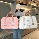 Woman holding pink and white quilted travel duffel bags with shoulder straps, ideal for stylish luggage, weekend trips, and carry-on essentials.