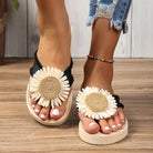 Women's sandals with large daisy flower design, featuring woven straw details and black straps. Perfect for summer fashion and casual beachwear.