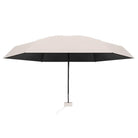 Beige compact travel umbrella with black interior, lightweight design, and ergonomic handle. Ideal for rain protection and easy portability.