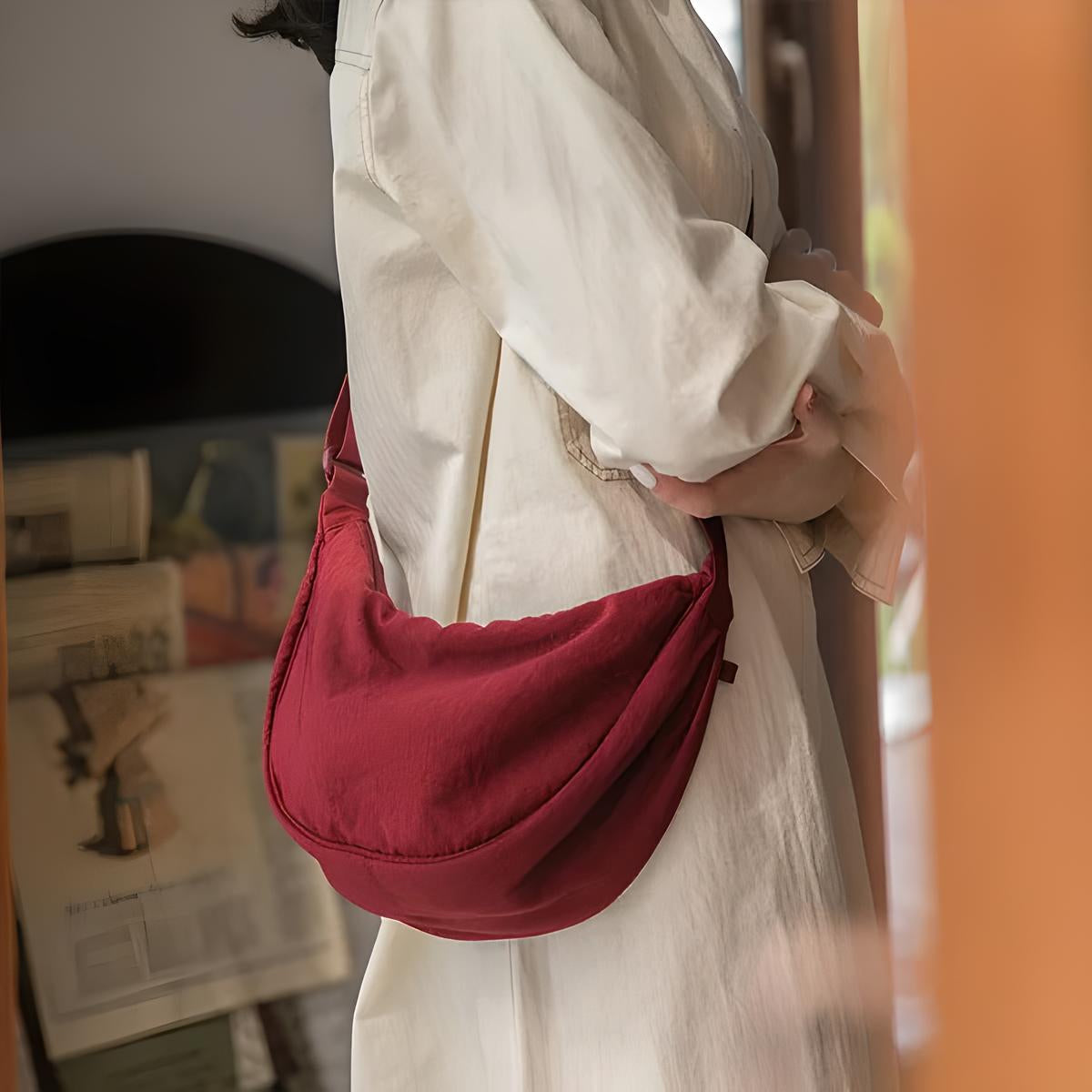 Woman in white dress holding a stylish red shoulder bag. Fashionable accessory, casual outfit, modern style, women's fashion trends.