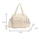 Cream quilted diaper bag with floral pattern, adjustable shoulder strap, and top handles. Dimensions: 24cm x 24cm x 13cm. Perfect for baby essentials.