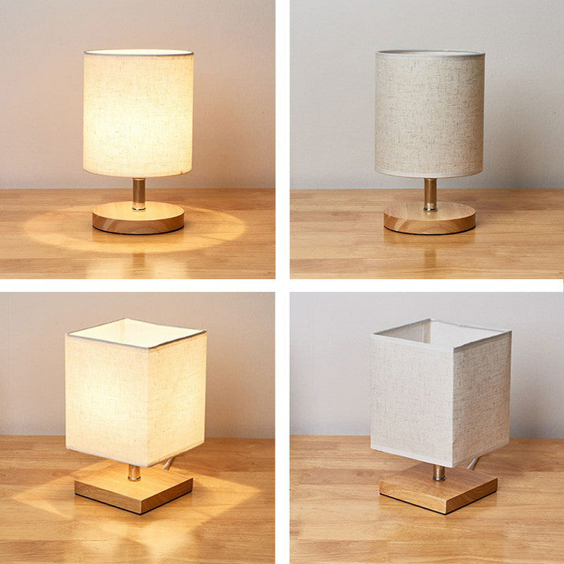 Set of four modern table lamps with cylindrical and square fabric shades on wooden bases, perfect for home decor and ambient lighting.