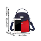 Red and black crossbody bag with adjustable strap, front pocket, and silver hardware, shown with smartphone for size comparison. Fashion accessory.