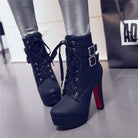 Black high-heeled ankle boots with lace-up front and buckle straps, featuring red soles, worn with metallic leggings. Fashion footwear for women.