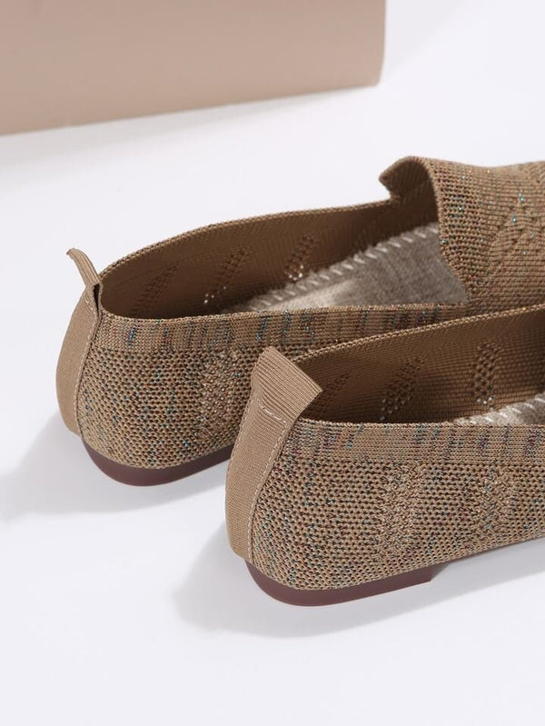 Beige woven loafers with textured fabric and brown soles, featuring a slip-on design. Perfect for casual wear. Comfortable and stylish footwear.