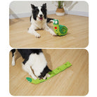 Border Collie playing with green interactive dog toy on wooden floor; durable, engaging pet toy for mental stimulation and entertainment.