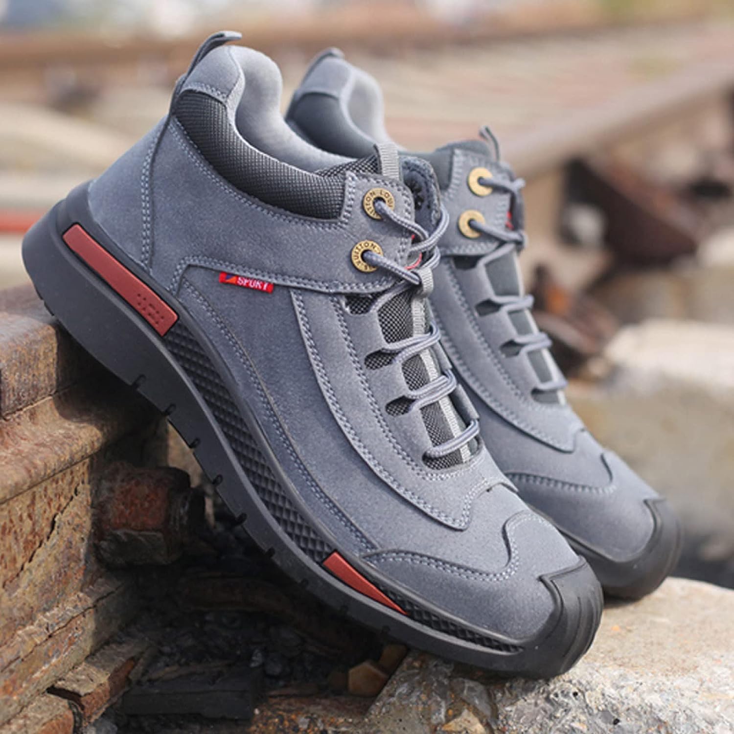 Gray hiking boots with durable rubber soles and red accents, designed for outdoor adventures. Ideal for trekking, offering comfort and style.