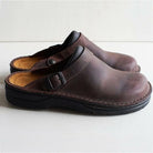 Brown leather clogs with adjustable strap, featuring a comfortable cushioned sole. Perfect for casual wear, durable footwear, stylish slip-on shoes.