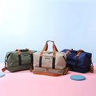 Three stylish duffel bags in green, beige, and navy with brown straps on a pink and blue background, perfect for travel and gym use.