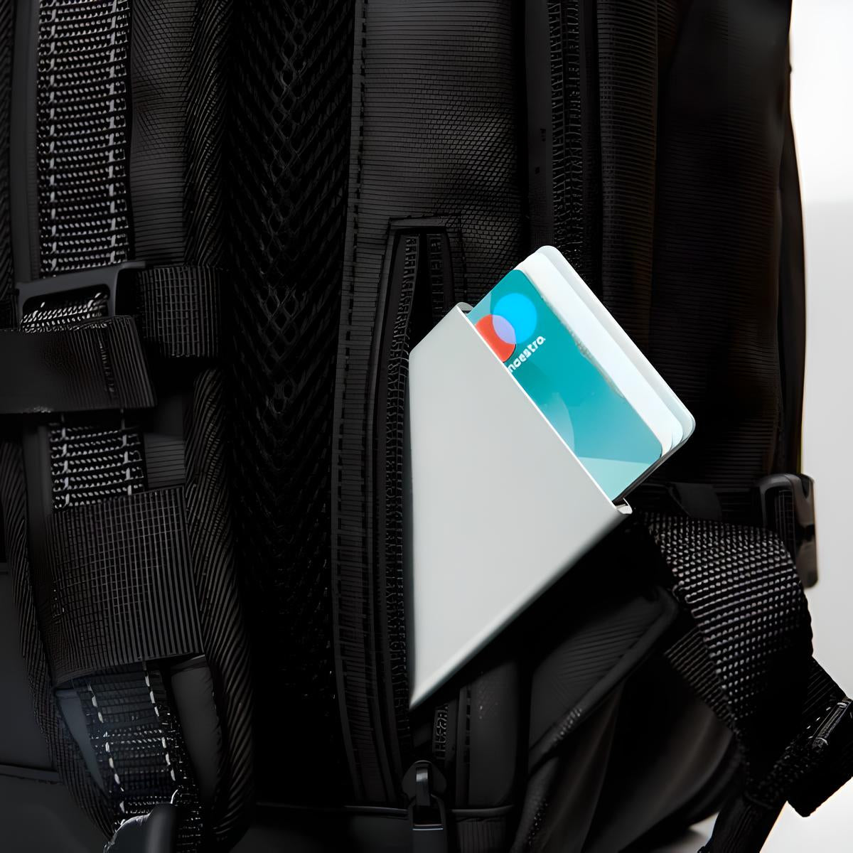 Black backpack with secure side pocket holding a modern smartphone, showcasing convenient storage and accessibility. Ideal for travel and daily use.