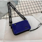 Blue hard-shell crossbody bag with "Forever Young" adjustable strap on a white quilted surface; stylish, durable travel accessory.