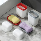 Colorful soap dishes with lids on a marble countertop, featuring yellow and purple soap bars. Modern bathroom accessories, soap storage solutions.