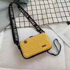 Yellow crossbody bag with "Forever Young" strap on a checkered background. Stylish, compact design ideal for travel and casual outings. Fashion accessory.