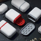 White and red soap dishes with drainage slots on a dark wet surface, featuring modern design and water-resistant material. Ideal for bathroom organization.