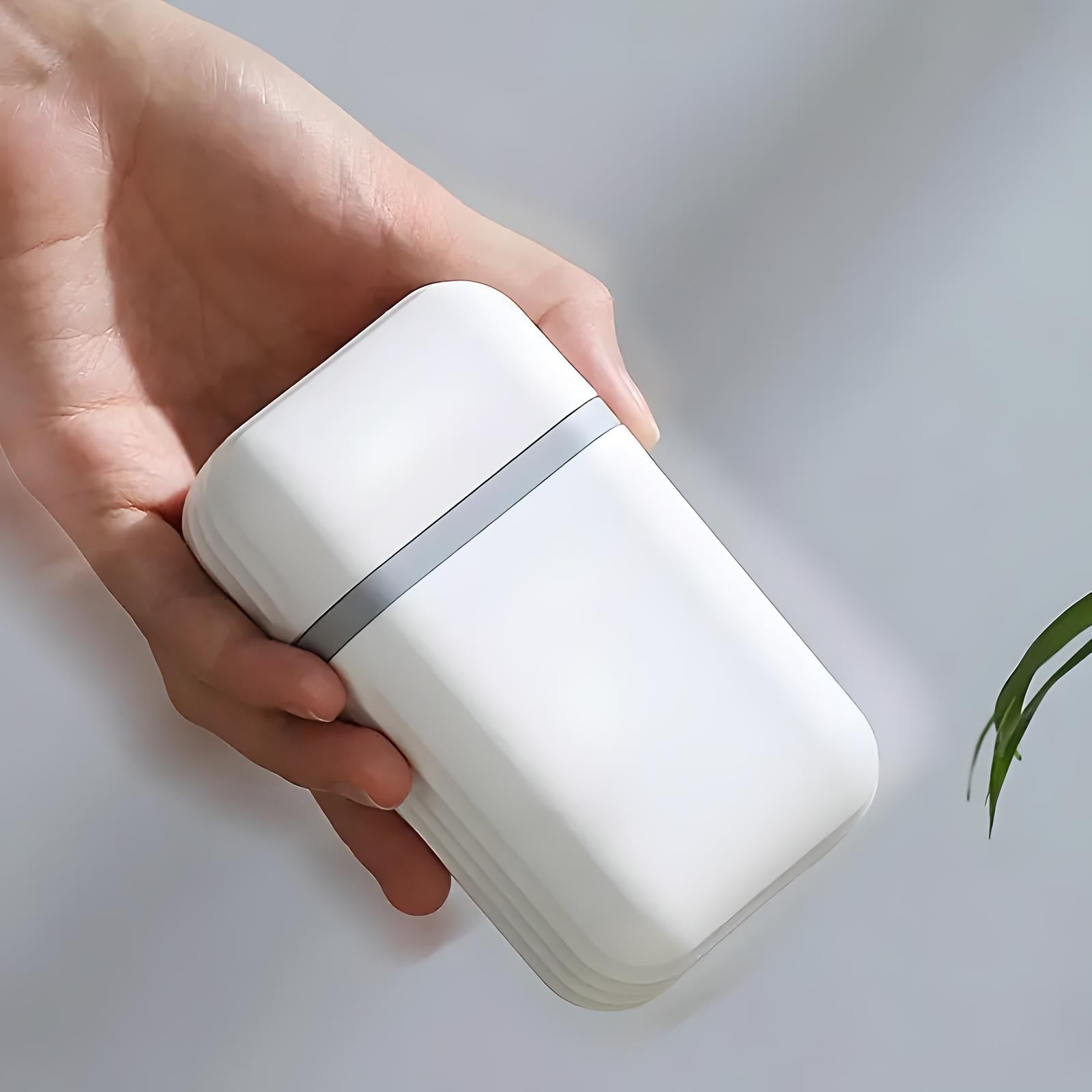 Hand holding a sleek white portable power bank with a silver accent, minimalist design, ideal for travel and on-the-go charging solutions.