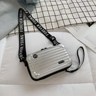 Silver crossbody bag with "Forever Young" strap on a white grid-patterned bedspread, modern design, ideal for fashion-forward accessories.