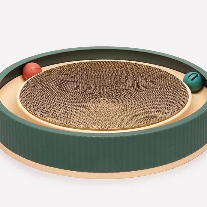 Cat scratcher toy with circular cardboard scratching pad, green and beige base, and two balls for interactive play. Perfect for feline entertainment.