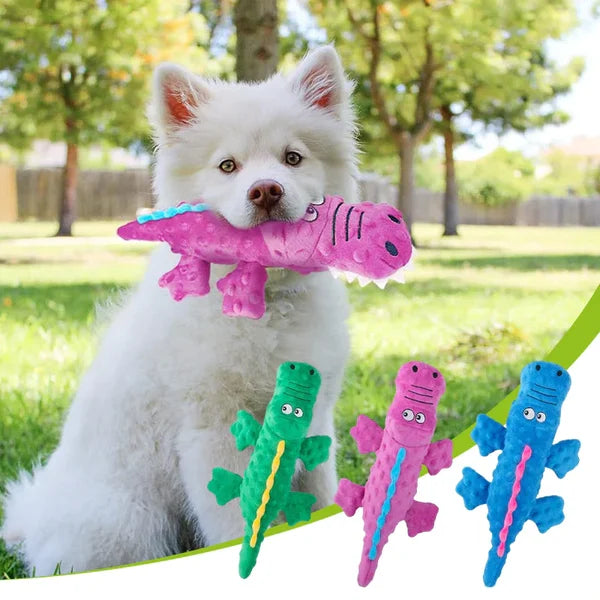 Fluffy white dog holding a pink dinosaur plush toy in a park, with green and blue dinosaur toys displayed below. Perfect pet chew toys for playful dogs.