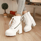 White chunky platform ankle boots with lace-up front, side zipper, and block heels, worn with light denim jeans. Fashionable women's footwear.