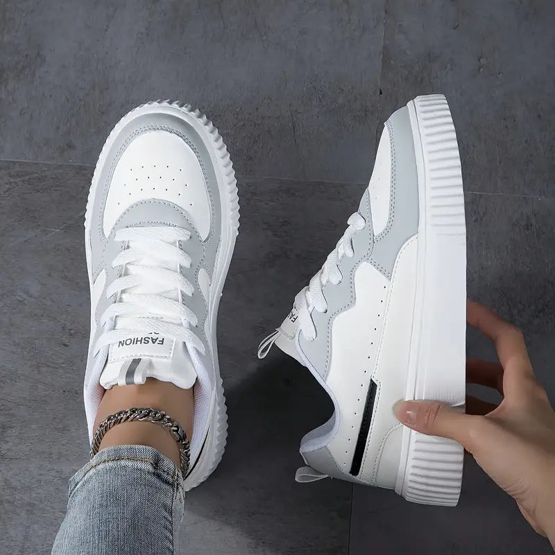 White and gray women's fashion sneakers with chunky soles, stylish design, and lace-up closure, perfect for casual wear and street style outfits.