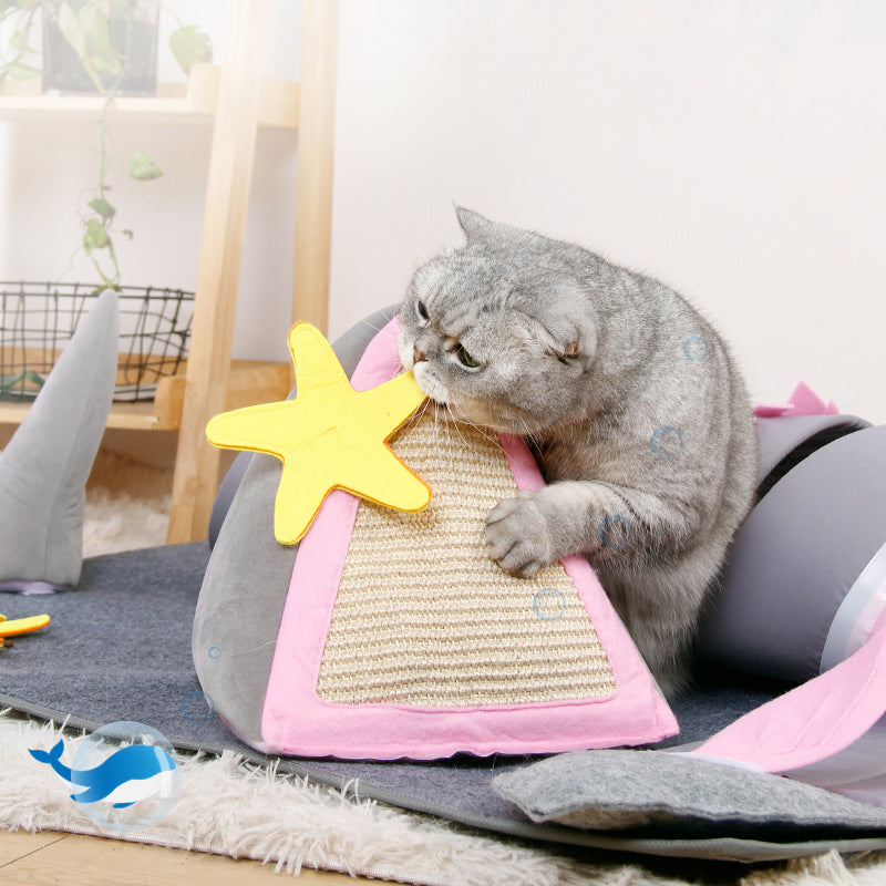 Gray cat playing with a pink and yellow star-shaped cat scratcher on a cozy indoor carpet. Perfect pet accessory for feline entertainment and exercise.