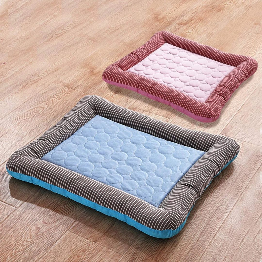 Two rectangular pet beds on wooden floor, featuring striped edges and quilted centers in pink and blue. Ideal for small dogs or cats.